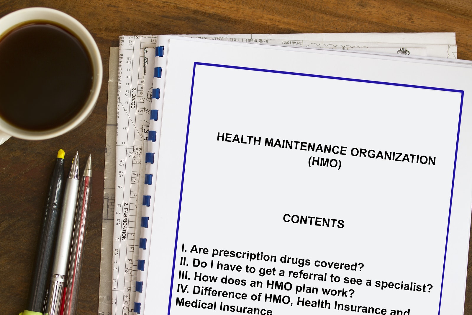 A binder with Health Maintenance Organization (HMO) information rests on a desk.